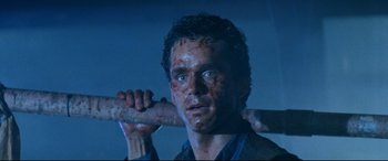 Movie still from “Razorback” (1984), directed by Russell Mulcahy – A person holding a baseball bat; Close Up shot, Low angle