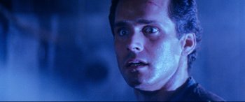 Movie still from “Razorback” (1984), directed by Russell Mulcahy – A man's face in a dark room; Close Up shot, Low angle