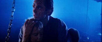 Movie still from “Razorback” (1984), directed by Russell Mulcahy – A man holding a child with blood all over his face; Close Up shot, Low angle