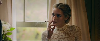 Movie still from “Ready or Not” (2019), directed by Matt Bettinelli-Olpin – A woman in a white lace dress smoking a cigarette; Close Up shot, Over the shoulder angle