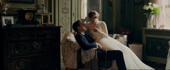 Movie still from “Ready or Not” (2019), directed by Matt Bettinelli-Olpin – A man and a woman sitting on a chair in front of a window; Medium shot, Over the shoulder angle