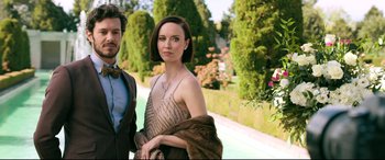 Movie still from “Ready or Not” (2019), directed by Matt Bettinelli-Olpin – A man and a woman posing for a picture in front of trees; Medium shot, Low angle