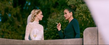 Movie still from “Ready or Not” (2019), directed by Matt Bettinelli-Olpin – Two women standing next to each other with a glass of wine; Medium shot, Over the shoulder angle