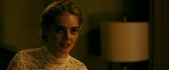 Movie still from “Ready or Not” (2019), directed by Matt Bettinelli-Olpin – A woman in a white lace top looking at the camera; Close Up shot, Over the shoulder angle
