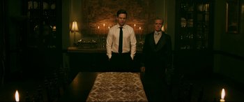 Movie still from “Ready or Not” (2019), directed by Matt Bettinelli-Olpin – Two men standing in front of a table in a room; Medium shot, Low angle