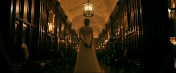 Movie still from “Ready or Not” (2019), directed by Matt Bettinelli-Olpin – A woman in a long white dress standing in a hallway; Wide shot, Low angle