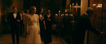 Movie still from “Ready or Not” (2019), directed by Matt Bettinelli-Olpin – A group of women standing next to each other in front of candles; Medium shot, Over the shoulder angle