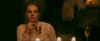Movie still from “Ready or Not” (2019), directed by Matt Bettinelli-Olpin – A beautiful young lady sitting in front of a glass of wine; Close Up shot, Over the shoulder angle