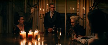 Movie still from “Ready or Not” (2019), directed by Matt Bettinelli-Olpin – A group of people sitting around a table with candles; Medium shot, Over the shoulder angle