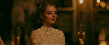 Movie still from “Ready or Not” (2019), directed by Matt Bettinelli-Olpin – A beautiful young lady wearing a white lace top; Close Up shot, Over the shoulder angle