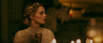 Movie still from “Ready or Not” (2019), directed by Matt Bettinelli-Olpin – A beautiful blonde woman holding a glass of wine; Close Up shot, Over the shoulder angle