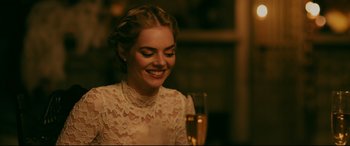 Movie still from “Ready or Not” (2019), directed by Matt Bettinelli-Olpin – A woman in a white lace dress holding a glass of champagne; Close Up shot, Over the shoulder angle