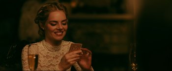Movie still from “Ready or Not” (2019), directed by Matt Bettinelli-Olpin – A beautiful young lady holding a playing card in her hands; Close Up shot, Over the shoulder angle