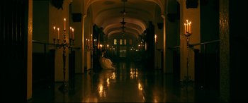 Movie still from “Ready or Not” (2019), directed by Matt Bettinelli-Olpin – A long hallway with candles lit up in the dark; Extreme Wide shot, High angle