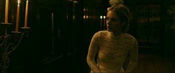 Movie still from “Ready or Not” (2019), directed by Matt Bettinelli-Olpin – A woman in a white dress standing in a dark room; Medium shot, Over the shoulder angle