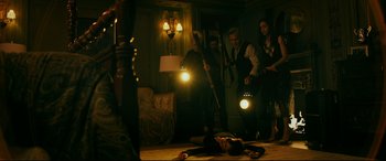 Movie still from “Ready or Not” (2019), directed by Matt Bettinelli-Olpin – A group of people standing in a living room; Wide shot, High angle