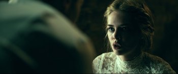 Movie still from “Ready or Not” (2019), directed by Matt Bettinelli-Olpin – A young woman looking into a mirror in a room; Close Up shot, Over the shoulder angle