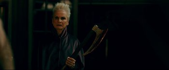 Movie still from “Ready or Not” (2019), directed by Matt Bettinelli-Olpin – An older woman holding an axe in a dark room; Close Up shot, Low angle