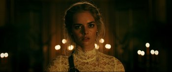 Movie still from “Ready or Not” (2019), directed by Matt Bettinelli-Olpin – A woman in a white lace dress with lights in the background; Close Up shot, Low angle