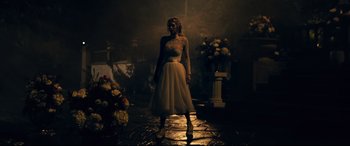 Movie still from “Ready or Not” (2019), directed by Matt Bettinelli-Olpin – A woman in a white dress standing in a dark room; Wide shot, Low angle