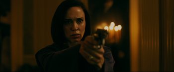 Movie still from “Ready or Not” (2019), directed by Matt Bettinelli-Olpin – A woman is holding a gun in a dark room; Close Up shot, Over the shoulder angle