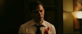 Movie still from “Ready or Not” (2019), directed by Matt Bettinelli-Olpin – A young man with a bloody shirt on his face; Close Up shot, Over the shoulder angle