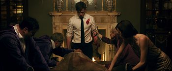 Movie still from “Ready or Not” (2019), directed by Matt Bettinelli-Olpin – A group of people standing in front of a fireplace; Medium shot, Low angle