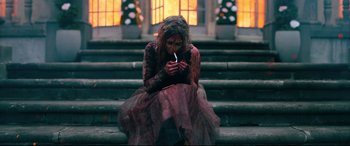 Movie still from “Ready or Not” (2019), directed by Matt Bettinelli-Olpin – A woman dressed as a zombie sitting on steps with a cigarette in her mouth; Medium shot, Over the shoulder angle