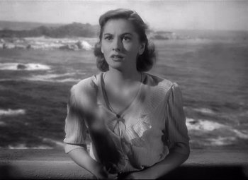 Movie still from “Rebecca” (1940), directed by Alfred Hitchcock – An old black and white photo of a woman looking out at the ocean; Close Up shot, High angle
