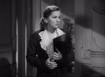 Movie still from “Rebecca” (1940), directed by Alfred Hitchcock – A woman holding a black folder in her hands; Medium shot, Over the shoulder angle