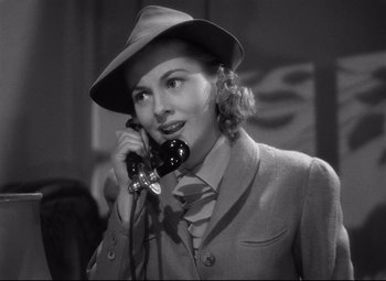 Movie still from “Rebecca” (1940), directed by Alfred Hitchcock – A woman talking on a phone while wearing a hat; Close Up shot, Low angle