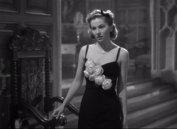 Movie still from “Rebecca” (1940), directed by Alfred Hitchcock – A black and white photo of a woman in a dress; Medium shot, High angle