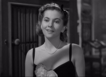 Movie still from “Rebecca” (1940), directed by Alfred Hitchcock – A black and white photo of a woman wearing a dress; Close Up shot, Over the shoulder angle