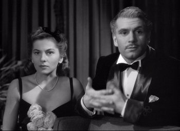 Movie still from “Rebecca” (1940), directed by Alfred Hitchcock – A man and a woman sitting next to each other; Medium shot, Over the shoulder angle