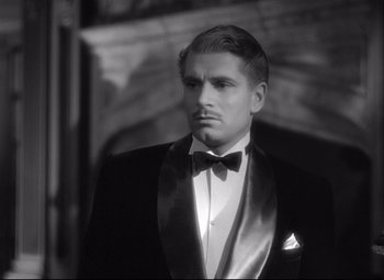 Movie still from “Rebecca” (1940), directed by Alfred Hitchcock – A black and white photo of a man in a tuxedo; Close Up shot, High angle