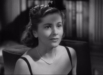 Movie still from “Rebecca” (1940), directed by Alfred Hitchcock – A black and white photo of a woman with a bow in her hair; Close Up shot, Over the shoulder angle