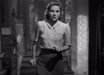 Movie still from “Rebecca” (1940), directed by Alfred Hitchcock – Black and white photograph of a woman walking; Medium shot, Low angle