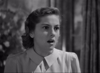 Movie still from “Rebecca” (1940), directed by Alfred Hitchcock – An old black and white photo of a young woman; Close Up shot, Over the shoulder angle