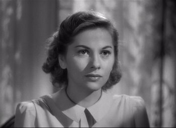 Movie still from “Rebecca” (1940), directed by Alfred Hitchcock – An old photo of a woman in a dress shirt and tie; Close Up shot, Over the shoulder angle