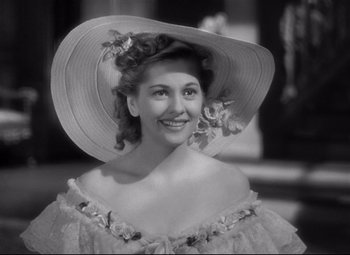 Movie still from “Rebecca” (1940), directed by Alfred Hitchcock – A black and white photo of a woman wearing a hat; Close Up shot, Over the shoulder angle