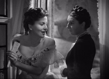 Movie still from “Rebecca” (1940), directed by Alfred Hitchcock – Two women with hair curlers talking to each other; Medium shot, Over the shoulder angle