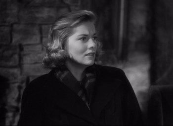Movie still from “Rebecca” (1940), directed by Alfred Hitchcock – A woman in a black coat and a plaid tie; Close Up shot, Over the shoulder angle