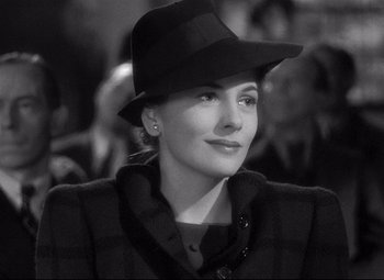 Movie still from “Rebecca” (1940), directed by Alfred Hitchcock – A black and white photo of a woman wearing a hat; Close Up shot, Over the shoulder angle