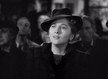 Movie still from “Rebecca” (1940), directed by Alfred Hitchcock – A woman wearing a black hat and a black coat; Close Up shot, Low angle