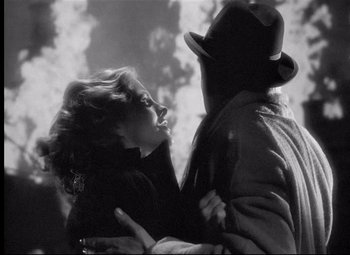 Movie still from “Rebecca” (1940), directed by Alfred Hitchcock – A man and a woman embracing each other in a black and white photo; Close Up shot, Over the shoulder angle