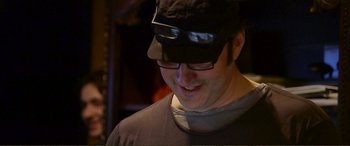 Movie still from “Hostage 911” (2018), directed by Robert Rodriguez – A person wearing glasses and a hat; Close Up shot, Over the shoulder angle