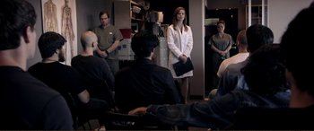 Movie still from “Hostage 911” (2018), directed by Robert Rodriguez – A group of people sitting in a room; Wide shot, Over the shoulder angle