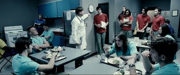 Movie still from “Hostage 911” (2018), directed by Robert Rodriguez – A group of people sitting at a table with plates of food; Medium shot, Over the shoulder angle
