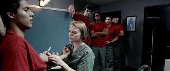 Movie still from “Hostage 911” (2018), directed by Robert Rodriguez – A group of people standing in a room; Medium shot, Low angle