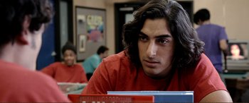 Movie still from “Hostage 911” (2018), directed by Robert Rodriguez – A young man sitting at a table in front of a laptop; Close Up shot, Over the shoulder angle